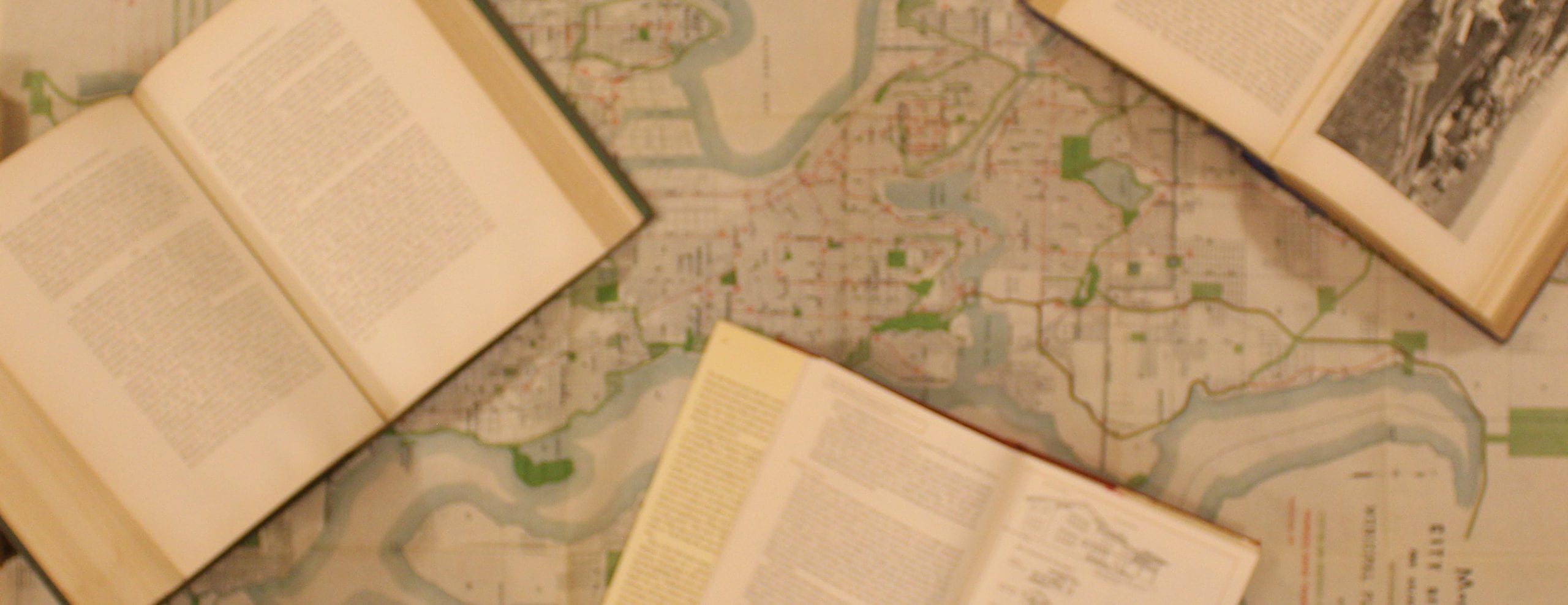 Three open books are laid out over a map of Seattle.