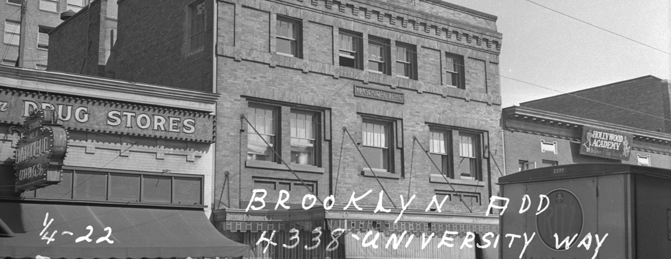A historic black and white photograph off the University Masonic Lodge. It is a three-story brick building, and the photo is captioned with the address "4338 University Way NE"