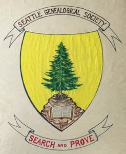 The Seattle Genealogical Society crest. There is an evergreen tree on a rock with a book at the base and the words Search and Prove appear on a banner at the bottom.